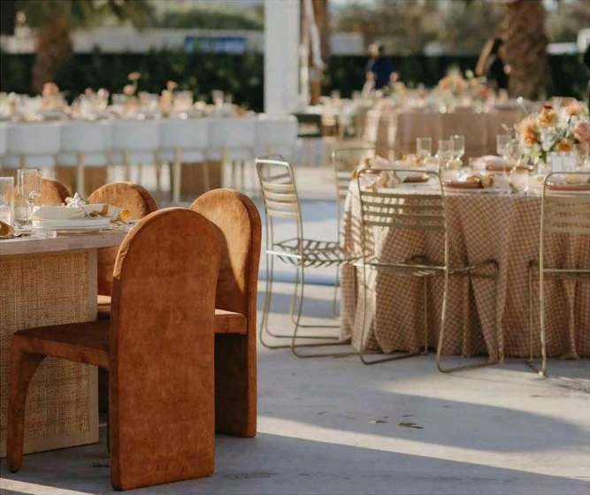 Montaje de colección con mesas vestidas, cristalería y sillas para eventos